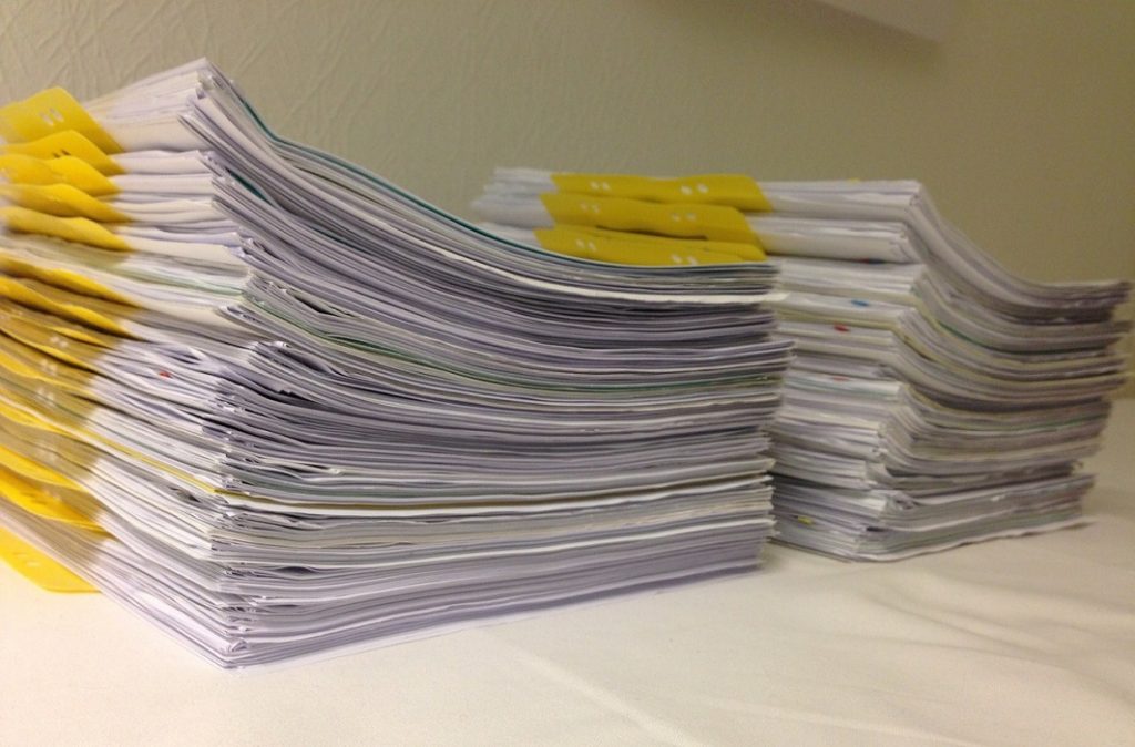 Documentos organizados em duas pilhas, com marcadores amarelos