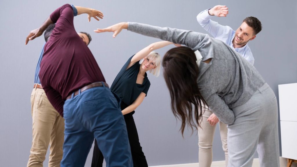 Grupo de pessoas fazendo ginástica laboral