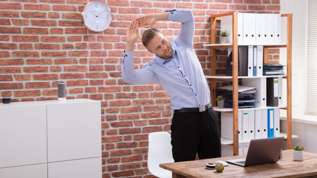 Homem realizando exercício de alongamento durante o trabalho