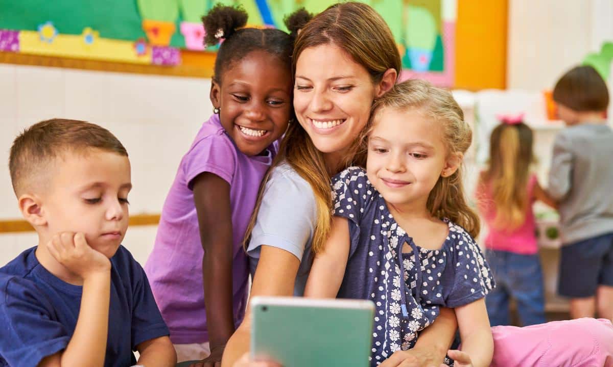 cuidador escolar com várias crianças em sala de aula