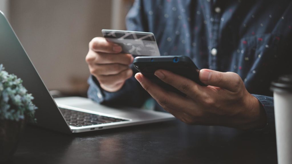 homem realizando uma tarefa digital com celular nas mãos