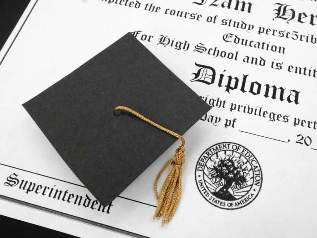 Chapéu de formatura em cima de um diploma.