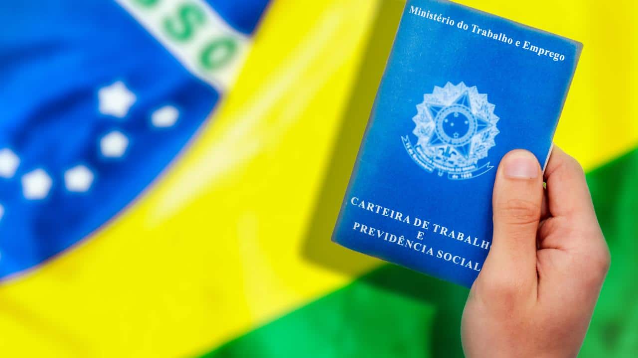 carteira de trabaho em destaque e uma bandeira do Brasil ao fundo
