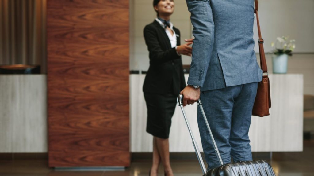 recepcionista atendendo um hospede em um hotel.