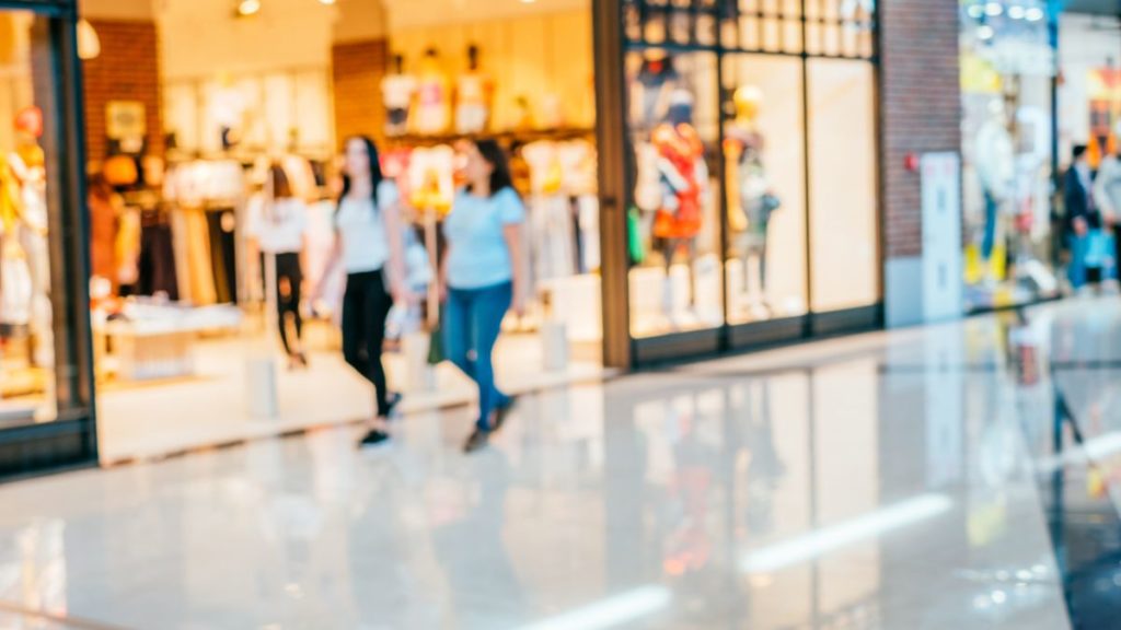 pessoas andando em frente a uma loja dentro do shopping.