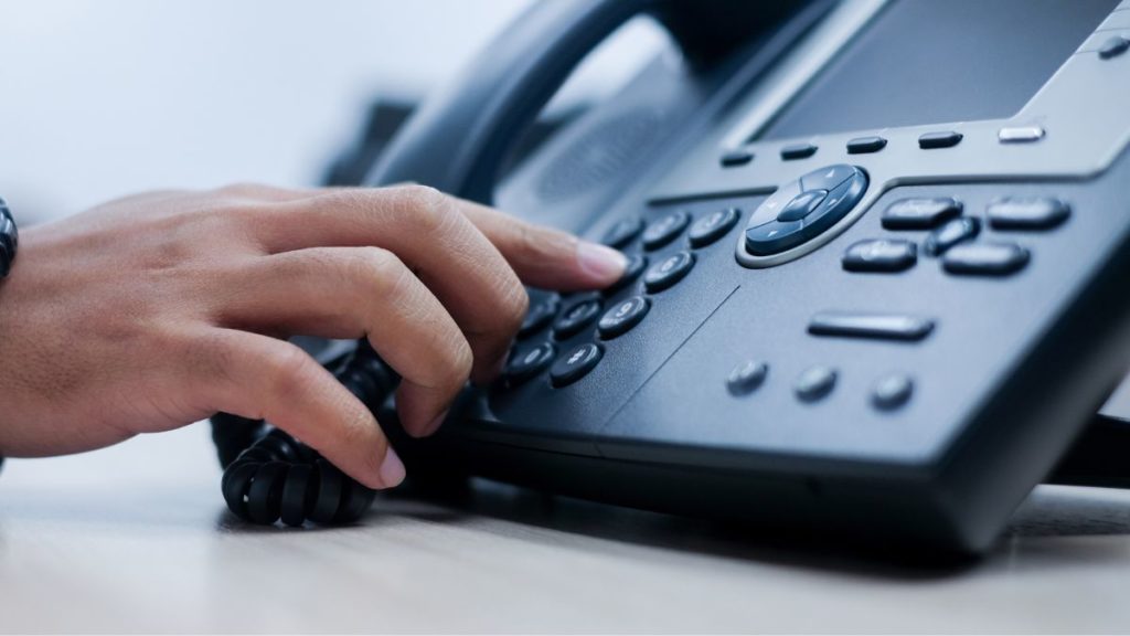 foco na mãe do recepcionista atendendo um telefone