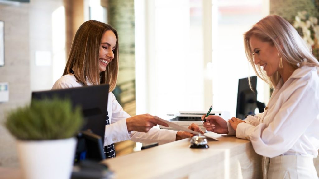 recepcionista recebendo um cliente no estabelecimento.