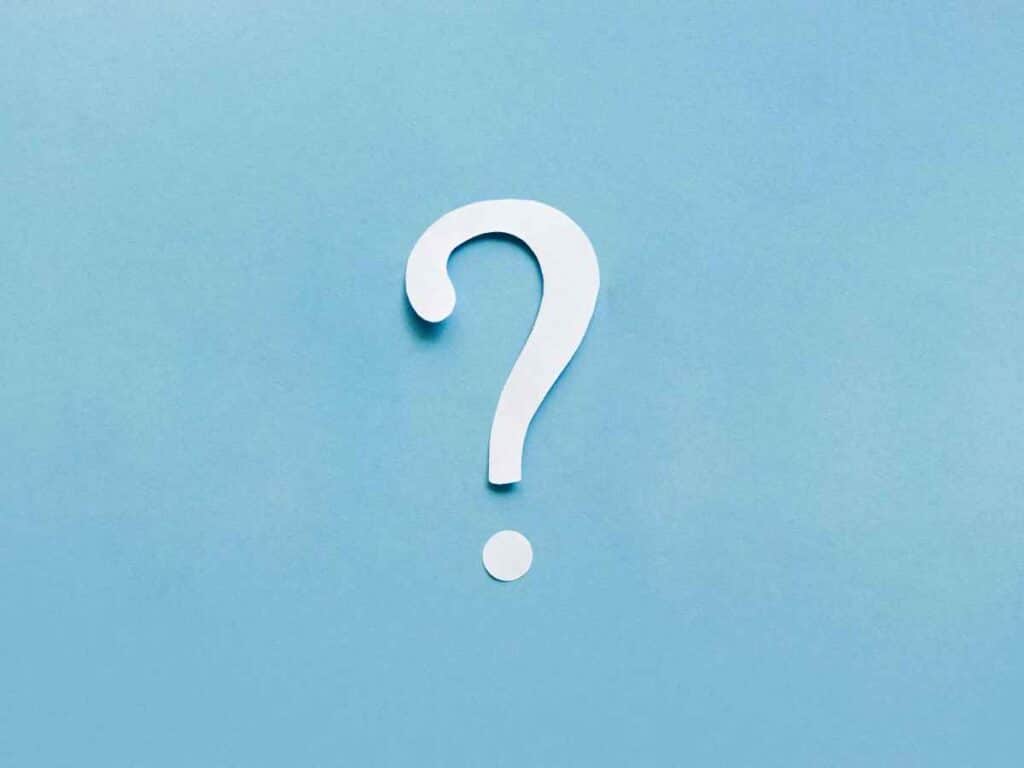 Símbolo de interrogação branco sobre fundo azul claro, representando dúvida, curiosidade ou questionamento.