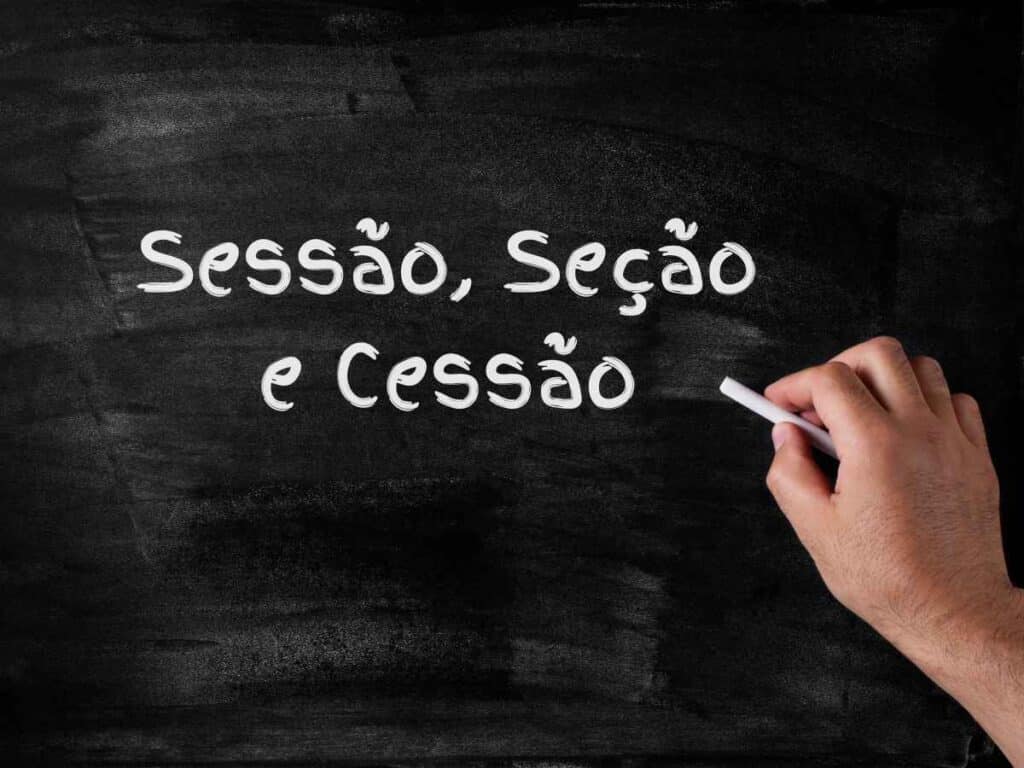 Mão escrevendo em uma lousa preta com giz branco a frase “Sessão, seção e cessão”
