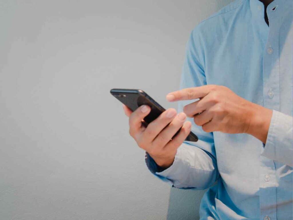 Ex-funcionário fazendo solicitação pelo celular para recorrer ao seu seguro-desemprego negado.