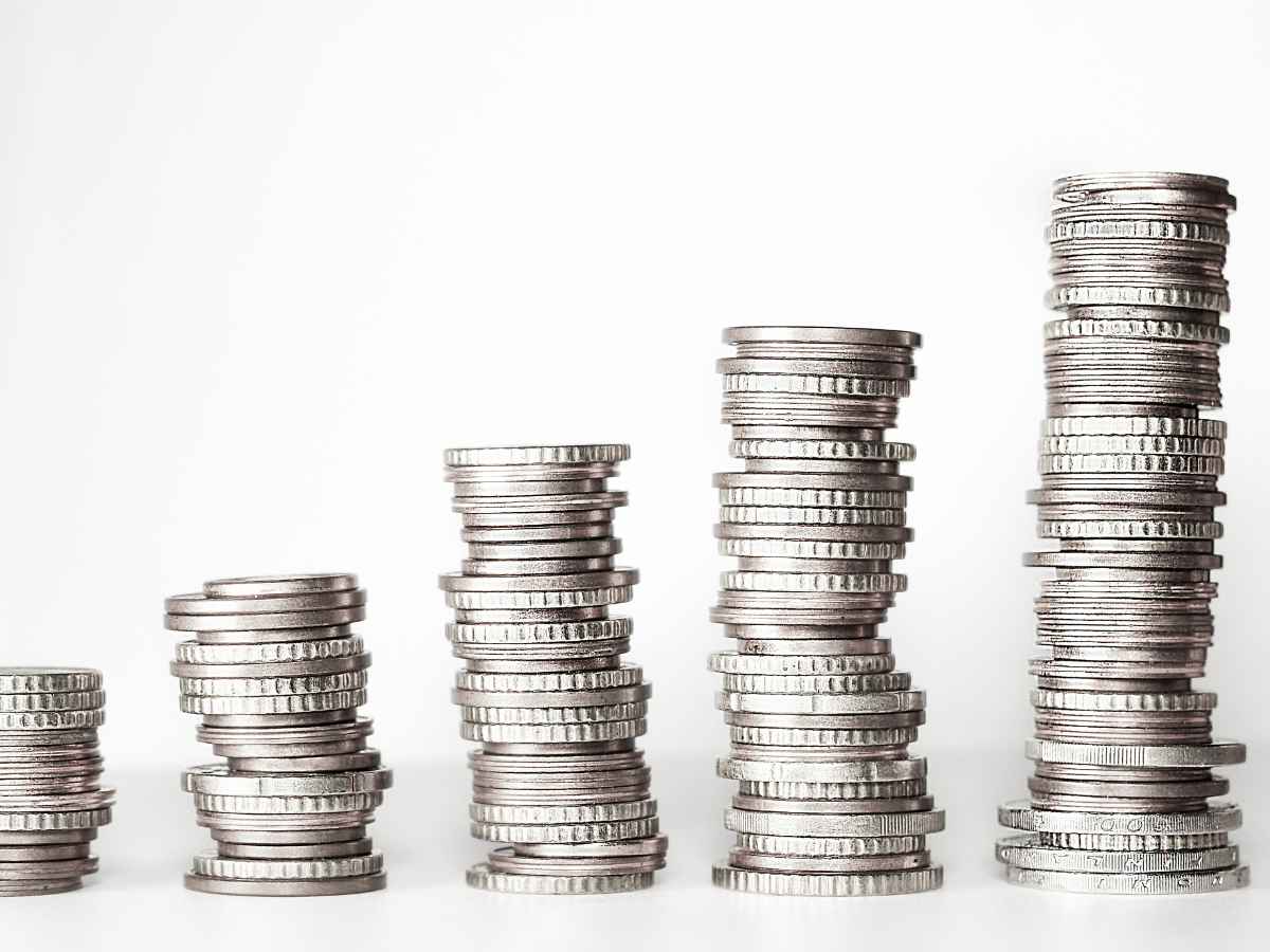 Várias pilhas de moedas prateadas alinhadas em ordem crescente