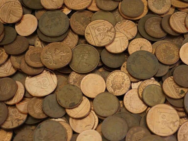 Moedas antigas de diferentes valores empilhadas e espalhadas