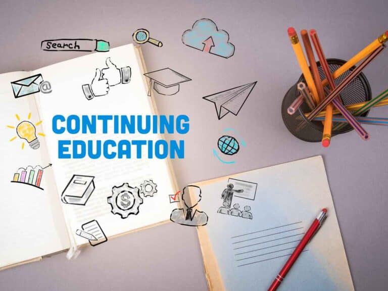 Cadernos, lápis e ilustrações relacionadas à educação continuada sobre mesa de estudos