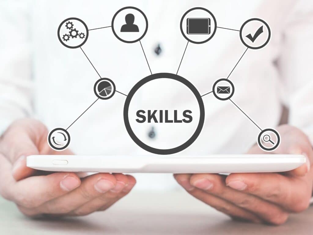 Pessoa segurando tablet com ilustração digital da palavra “Skills” e ícones conectados, simbolizando competências profissionais, tecnologia e qualificação profissional