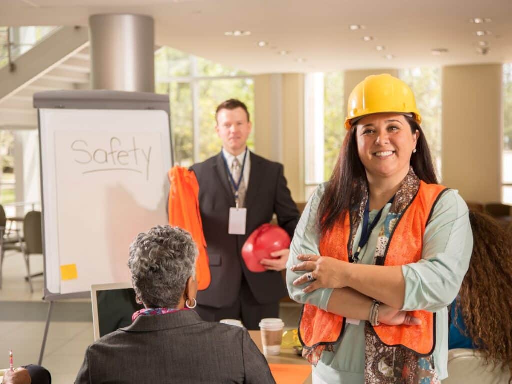 Profissional usando capacete e colete refletivo durante treinamento de segurança do trabalho