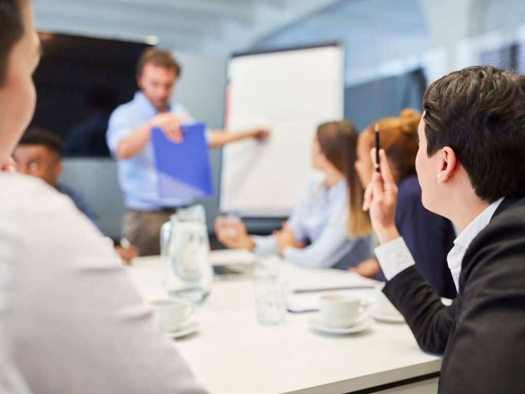Profissionais participam de treinamento em empresa, acompanhando uma apresentação
